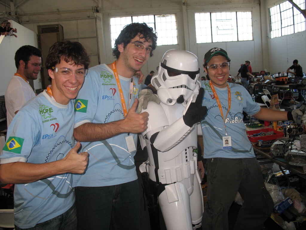 Three RioBotz members giving thumbs up next to a stormtrooper at the competition